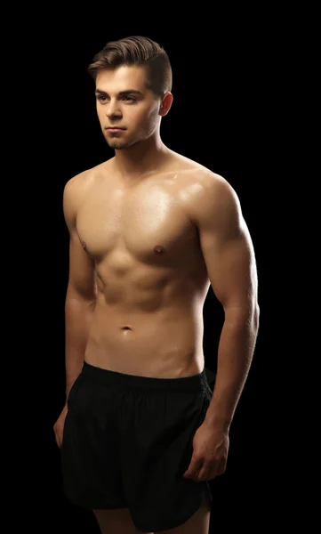 Muscle young man on dark background — Stock Photo, Image