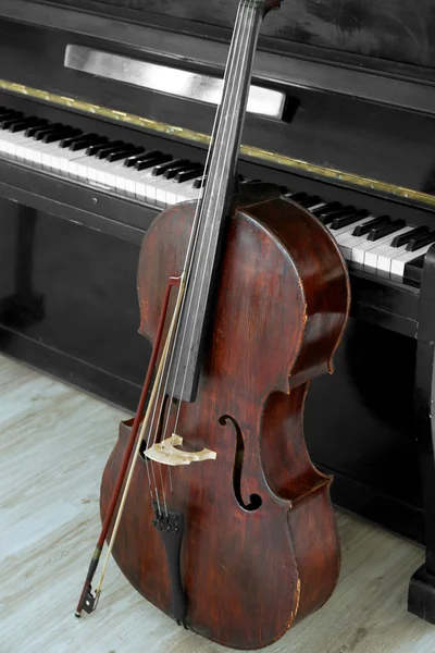 Violoncelo perto de piano, dentro de casa — Fotografia de Stock