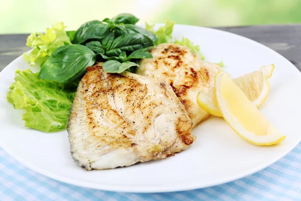 Plato de filete de pescado con verduras y limón en la mesa de cerca — Foto de Stock