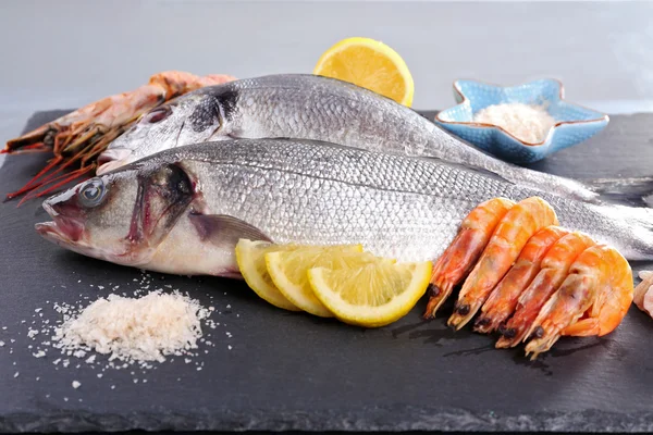 Čerstvé ryby a krevety s kořením na šedém pozadí — Stock fotografie