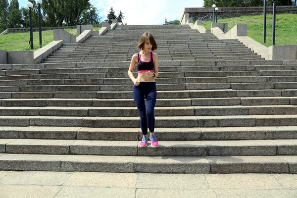 Junge Frau joggt Treppen im Freien — Stockfoto