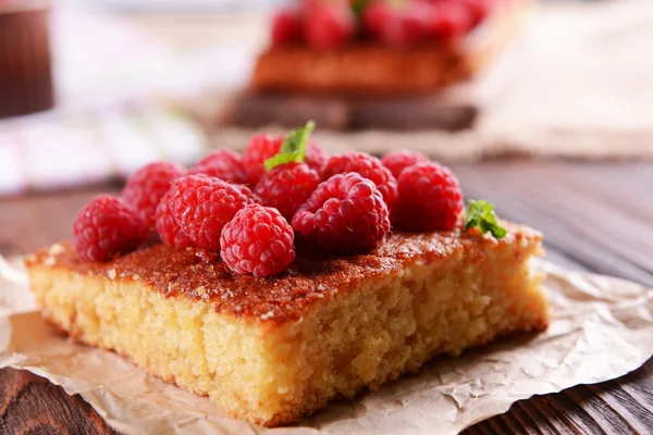 Tarte fraîche à la framboise sur parchemin sur table en bois, gros plan — Photo