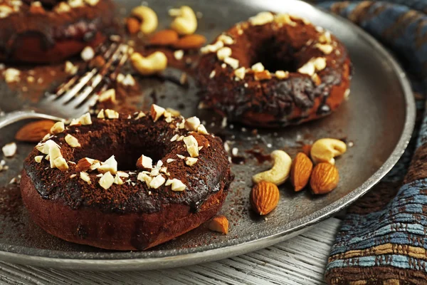 Heerlijke donuts met chocolade slagroom en noten op tafel close-up — Stockfoto
