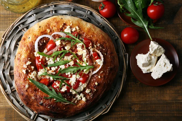 Greek homemade pizza with ham,onion, roasted tomato, creamy feta on wooden table background — Stock Photo, Image