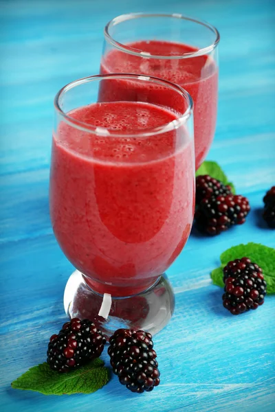 Glasses of blackberry smoothie on wooden table, closeup — Stock Photo, Image