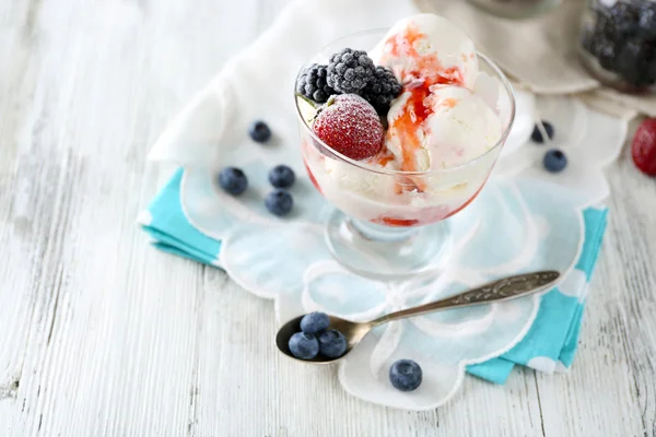Delicioso sorvete com frutas frescas congeladas e molho, na cor de fundo de madeira — Fotografia de Stock