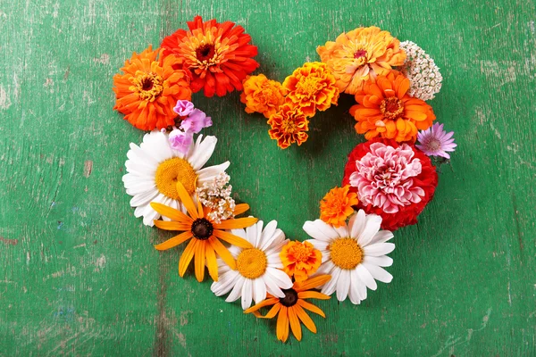 Fresh colorful flowers in shape of heart wooden table, closeup — Stock Photo, Image