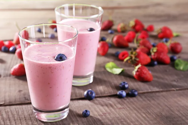 Glasses of berry smoothie on wooden table, closeup — Stock Photo, Image