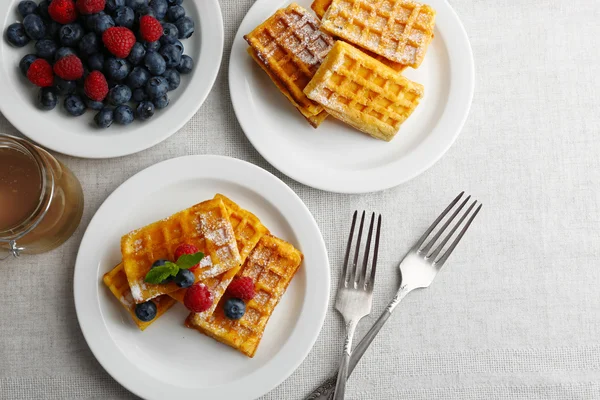 Sweet homemade waffles with forest berries and sauce on table background — Stock Photo, Image