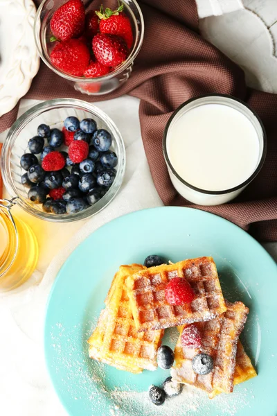 Sweet homemade waffles with forest berries on plate, on light background — Stock Photo, Image