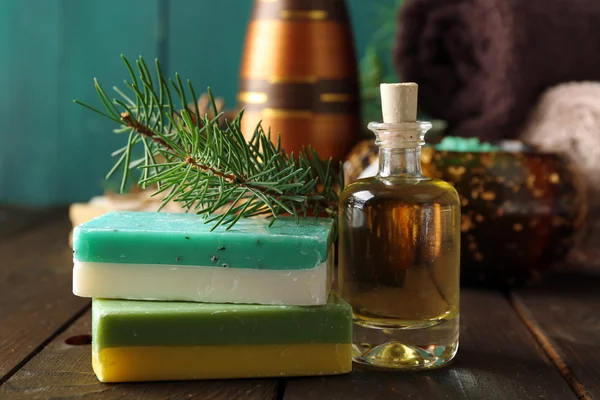 Esenciální olej z borovice, mýdlo a krém s borovice extraktu a lázeňské procedury na dřevěné pozadí — Stock fotografie