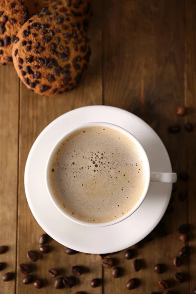 Xícara de café com biscoitos e grãos de café na mesa de madeira, vista superior — Fotografia de Stock