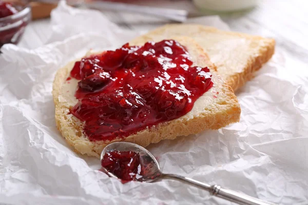 Bread with butter and homemade jam on crumpled parchment, closeup — Stock Photo, Image