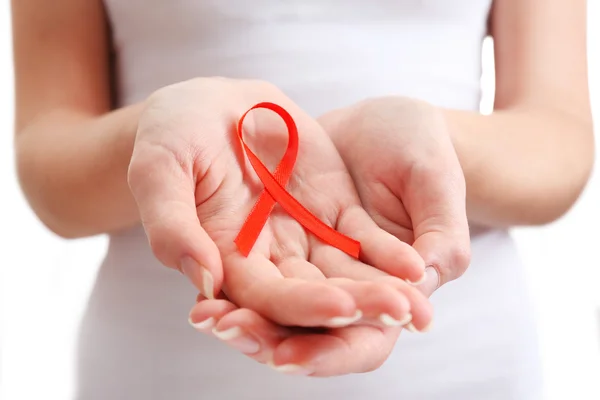 Female hands holding red ribbon sign, closeup — Stock Photo, Image