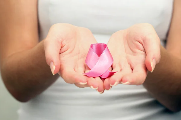 Female hands holding pink ribbon sign, closeup — Stock Photo, Image