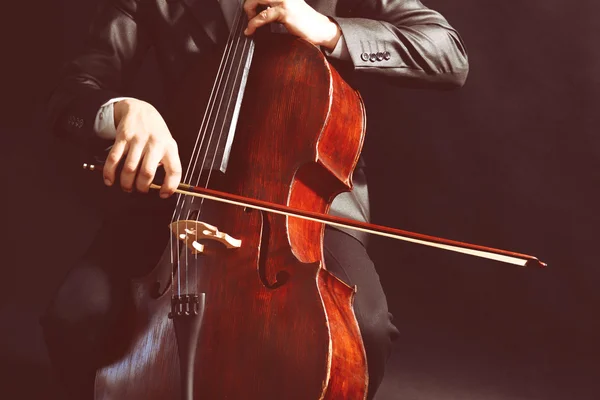 Homem tocando violoncelo no fundo escuro — Fotografia de Stock