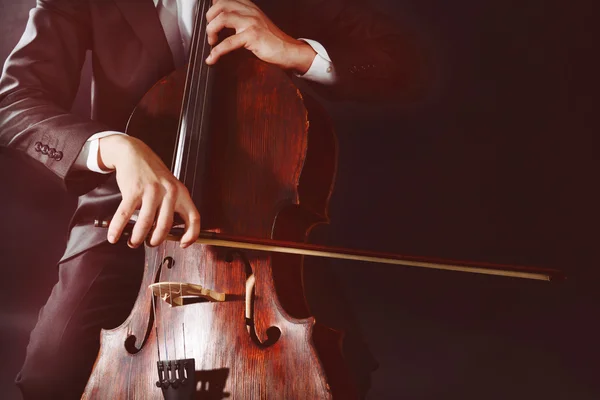 Man playing on cello on dark background — Stock Photo, Image