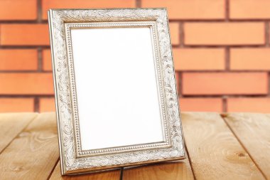 Eski boş çerçeve ayakta masanın üstüne tuğla duvar arka plan
