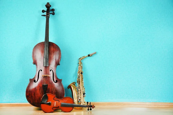 Musical instruments on turquoise wallpaper background — Stock Photo, Image