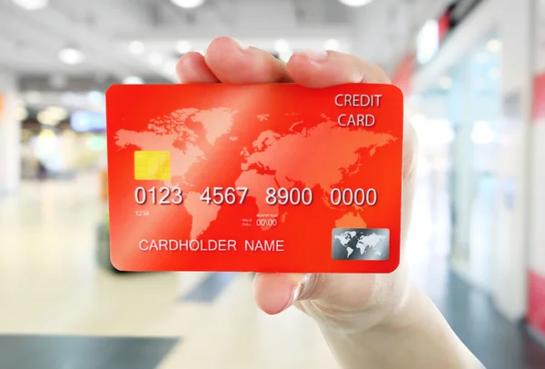 Hand holding credit card on abstract background — Stock Photo, Image