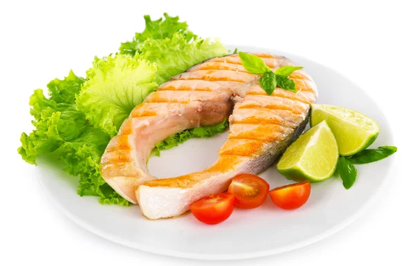 Tasty grilled salmon with tomato and lime on plate close up — Stock Photo, Image