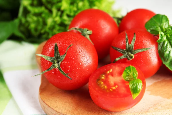 Kirschtomaten mit Basilikum auf Holztisch aus nächster Nähe — Stockfoto