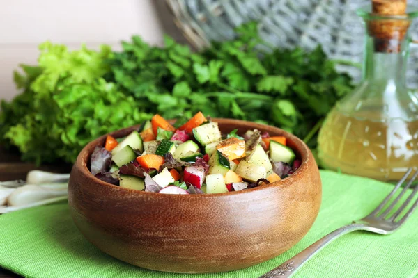 Trä skål med färska grönsaker sallad på bordet, närbild — Stockfoto