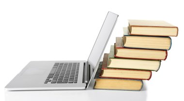 Dizüstü bilgisayar ile kitap yığını