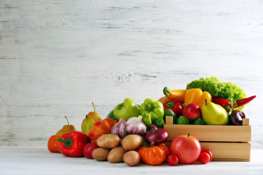 Ahşap arka planda bir yığın taze meyve ve sebze.