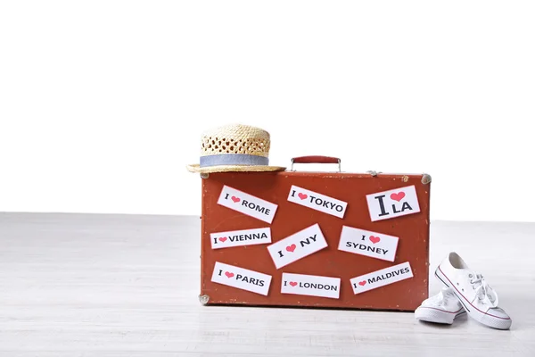 Suitcase with stickers, gumshoes and hat — Stock Photo, Image