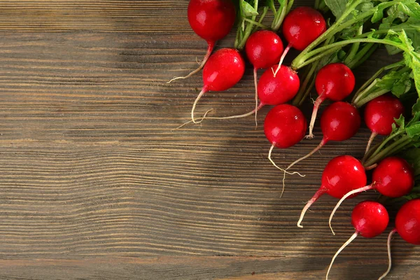 Rábano rojo fresco sobre fondo de madera — Foto de Stock