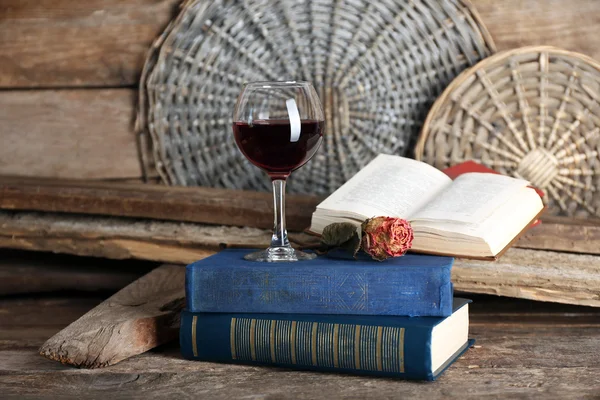 Bela composição com copo de vinho com livros antigos na mesa de perto — Fotografia de Stock