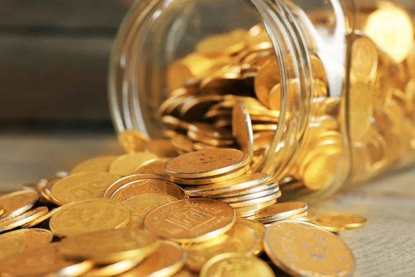 Frasco de vidro com moedas na mesa de madeira, close-up — Fotografia de Stock