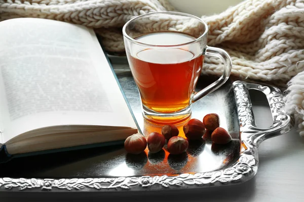 Cup of tea with book on metal tray, closeup — Stock Photo, Image