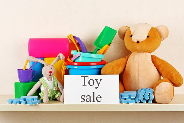 Toys for sale on shelf, on light wall background — Stock Photo, Image