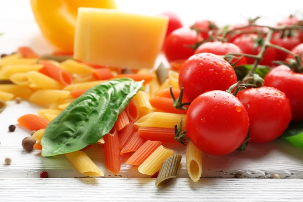 Паста с помидорами, сыром и лимоном на цветном деревянном фоне — стоковое фото