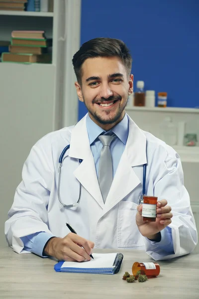 Médico segurando garrafa com cannabis medicinal de perto — Fotografia de Stock