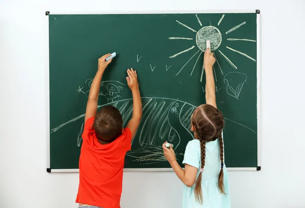 Niños dibujando en pizarra en la escuela — Foto de Stock