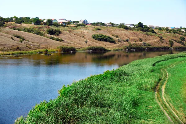 Mavi gökyüzü arka plan Nehri ile çayır — Stok fotoğraf