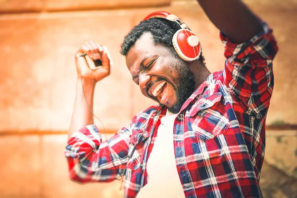 Hombre afroamericano escuchando música con auriculares al aire libre —  Fotos de Stock