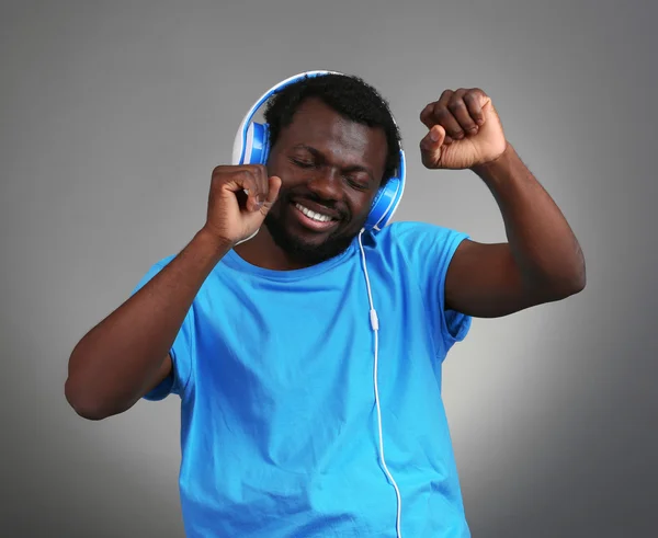 Afrika Amerika pria dengan headphone pada latar belakang abu-abu — Stok Foto