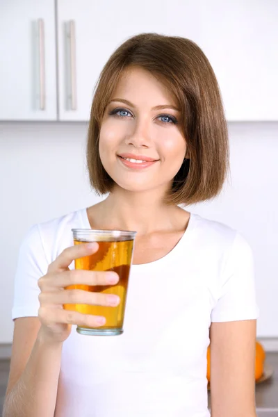Unga vackra kvinnan visar glas äppeljuice — Stockfoto