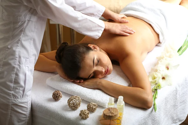 Jonge vrouw op massagetafel in spa schoonheidssalon — Stockfoto