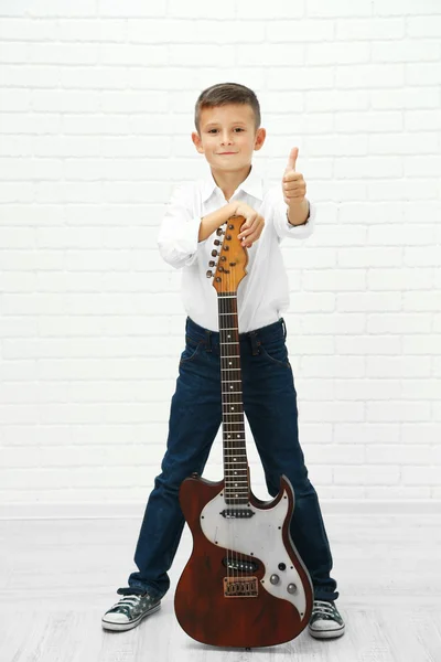 Ragazzino con chitarra su sfondo chiaro — Foto Stock