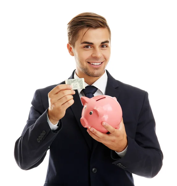 Элегантный мужчина держит копилку с деньгами, изолированными на белом — стоковое фото
