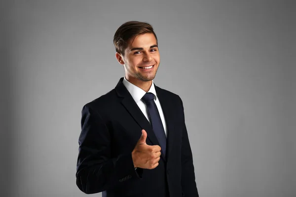 Elegante hombre de traje sobre fondo gris —  Fotos de Stock