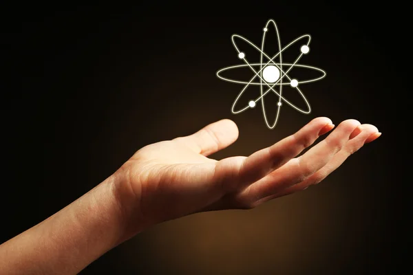 Ruka s obrázkem atomu — Stock fotografie
