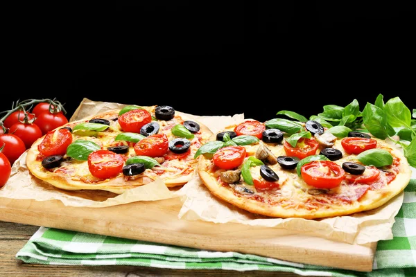 Tasty pizza with vegetables and basil on black background — Stock Photo, Image