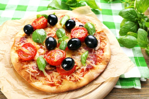 Gustosa pizza con verdure e basilico in tavola da vicino — Foto Stock