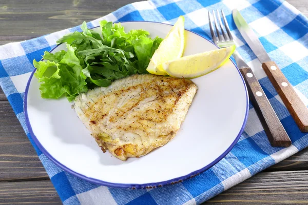 Schotel van visfilet met sla en citroen op tafel close-up — Stockfoto
